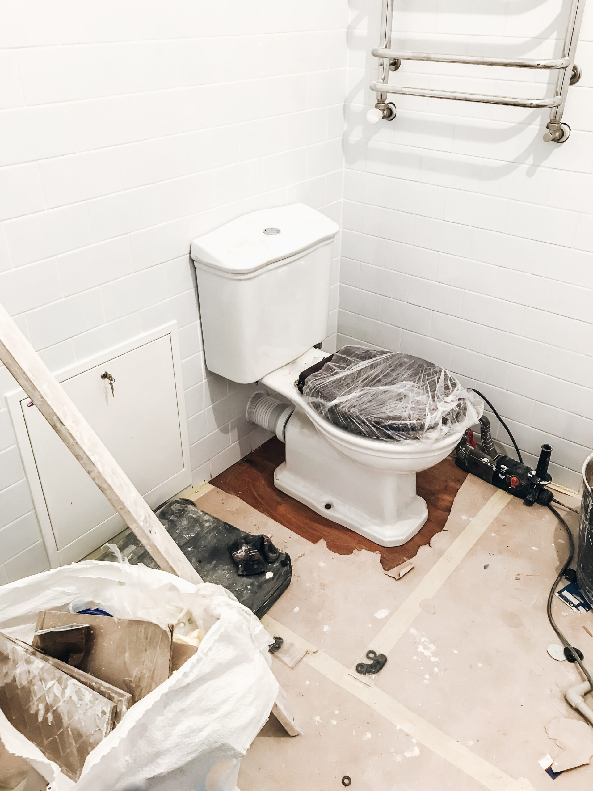 bathroom renovation concept. stylish white lavatory pan and wooden sitting, modern  white ceramic tiles on wall. repairing and working in home, space for text